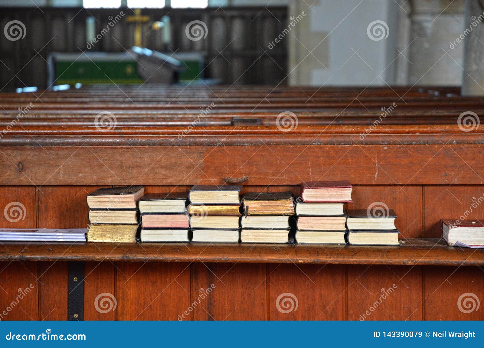 spiritually uplifting hymn books stacked on church bench