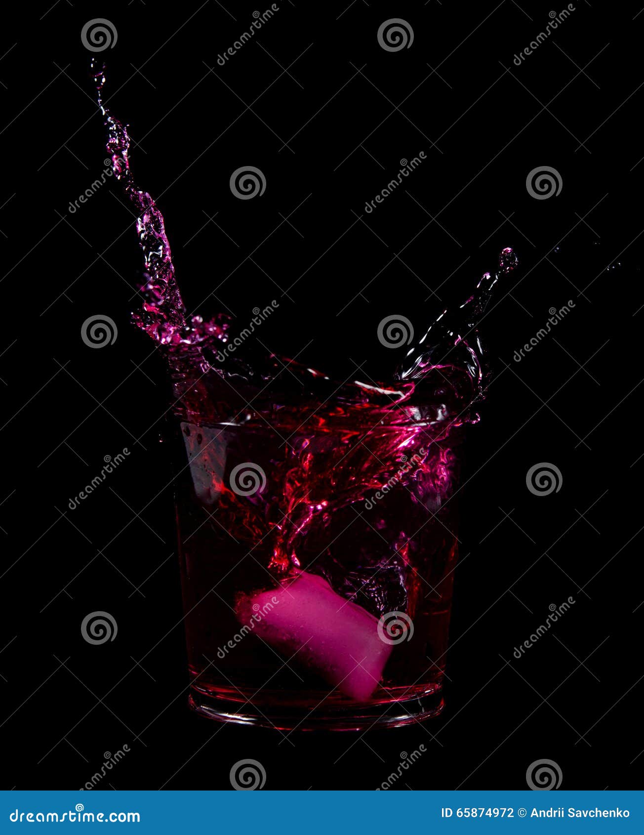 Splash From Ice Cube In A Glass Of Red Water Or Drink Stock Photo