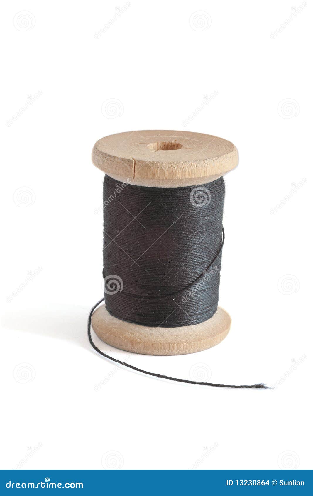 Black Thread on an Old Wooden Spool and Sewing Needle Stock