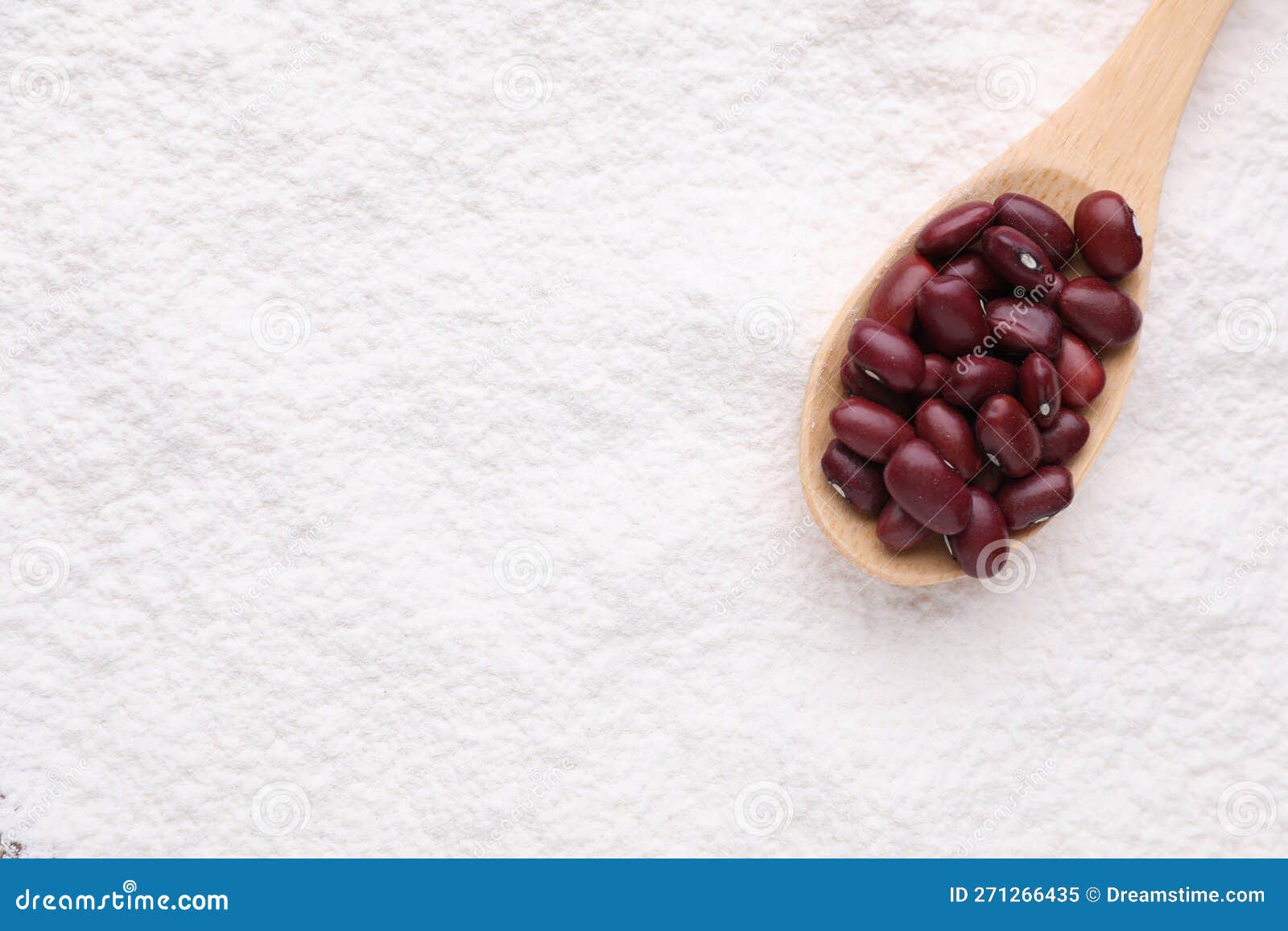 Spoon with Brown Seeds on Kidney Bean Flour, Top View. Space for Text