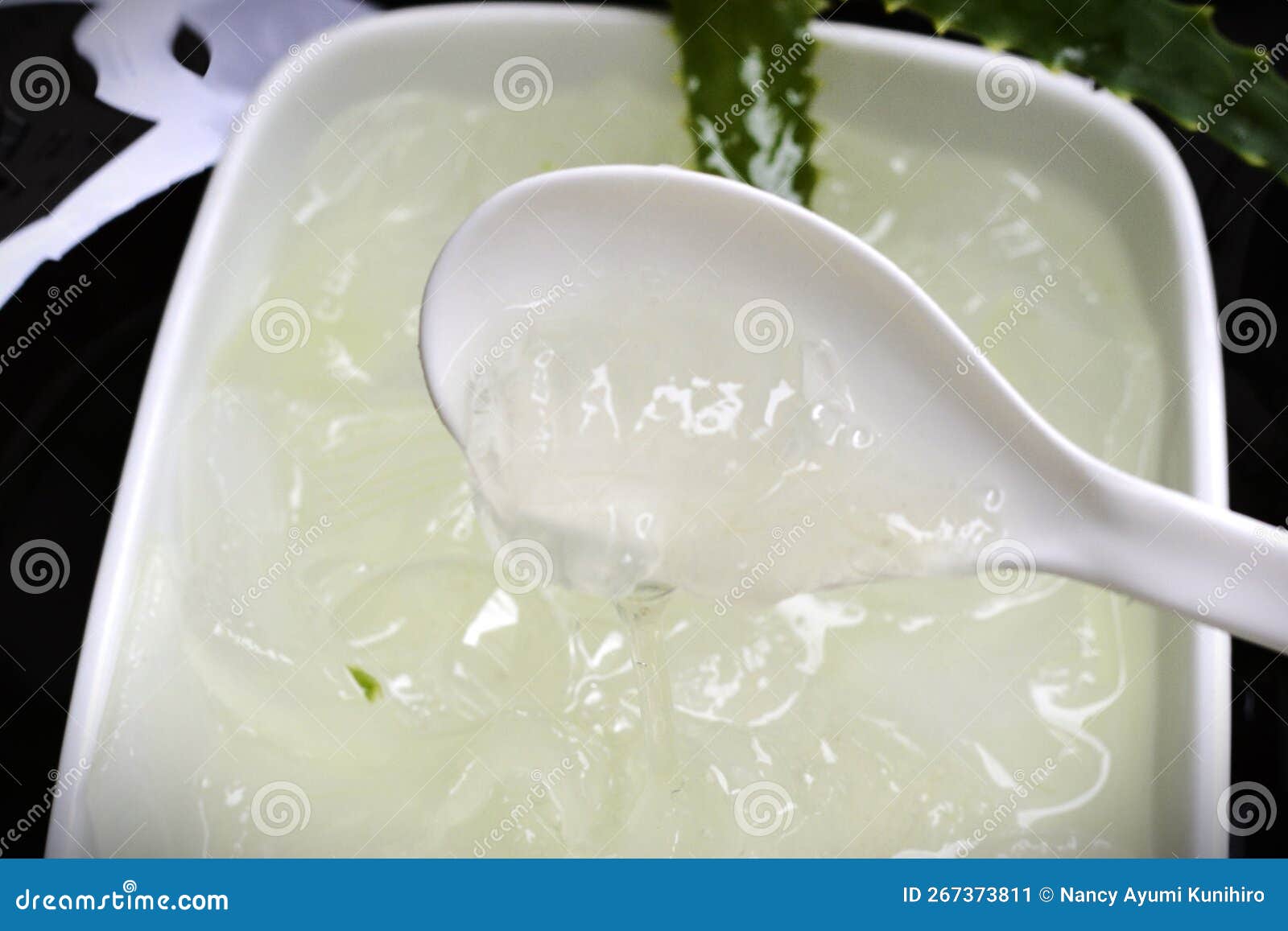 in the spoon the juice and goo taken from the aloe vera