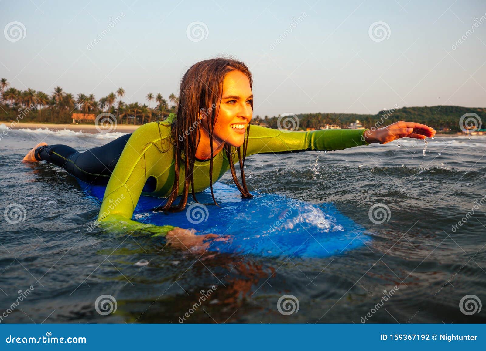 Sporteert Een Vrouw in Een Duikpak Dat Op Een Surfbord Ligt Te Wachten Op Een Grote Golf Surf Meisje in Een Waterpak Dat Bi Stock Foto - Image of meisje, vrij: