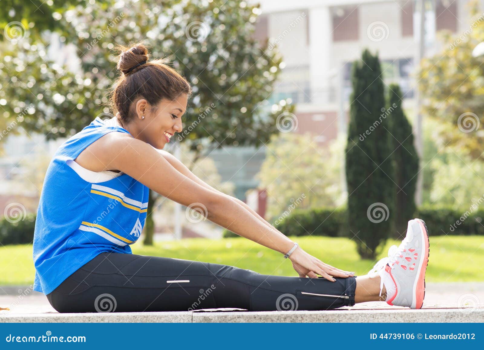 Sportieve glimlachende en vrouw die, gezonde levensstijl opleiden uitoefenen. Atletische vrouw die in het park uitoefenen