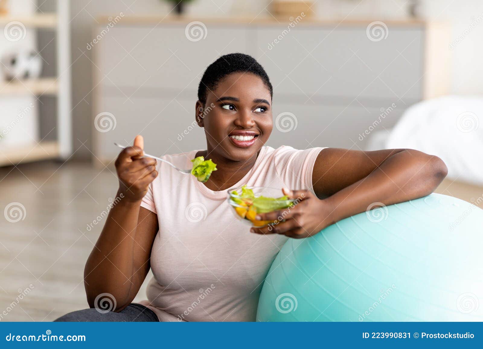 Fitness Concept. Portrait of happy black plus size woman holding