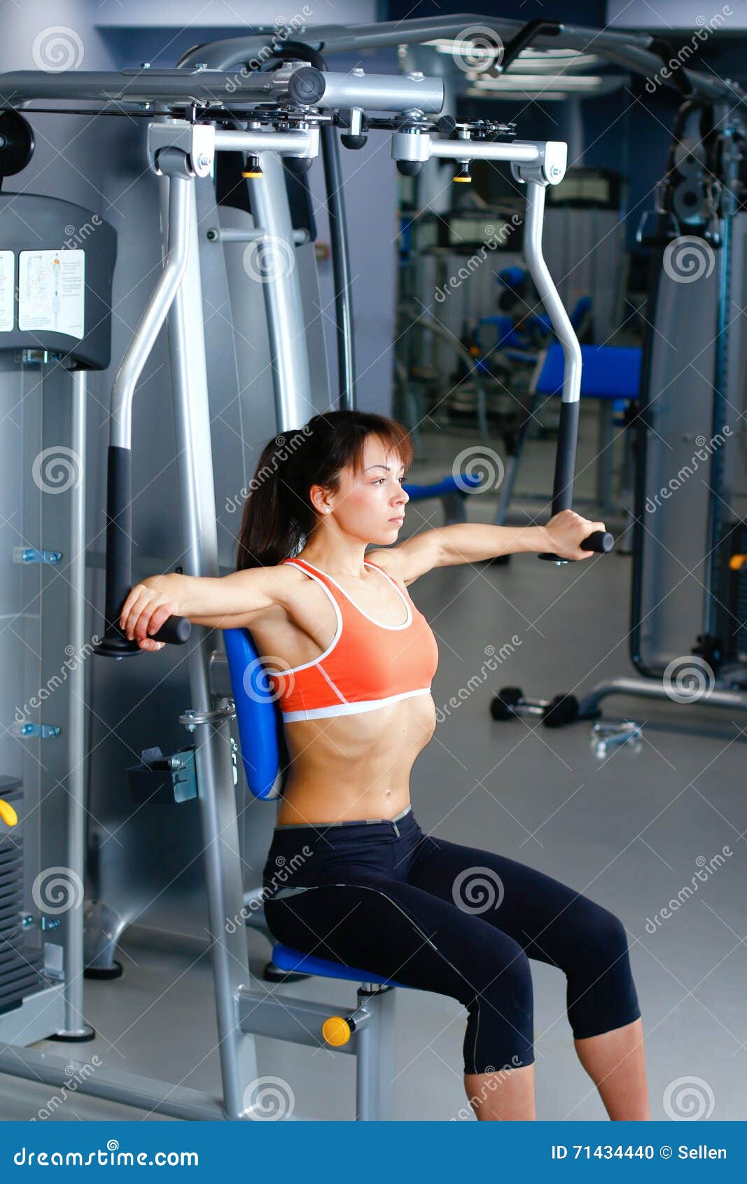 Sports Young Woman Doing Exercises on Trainer Back Machine in the