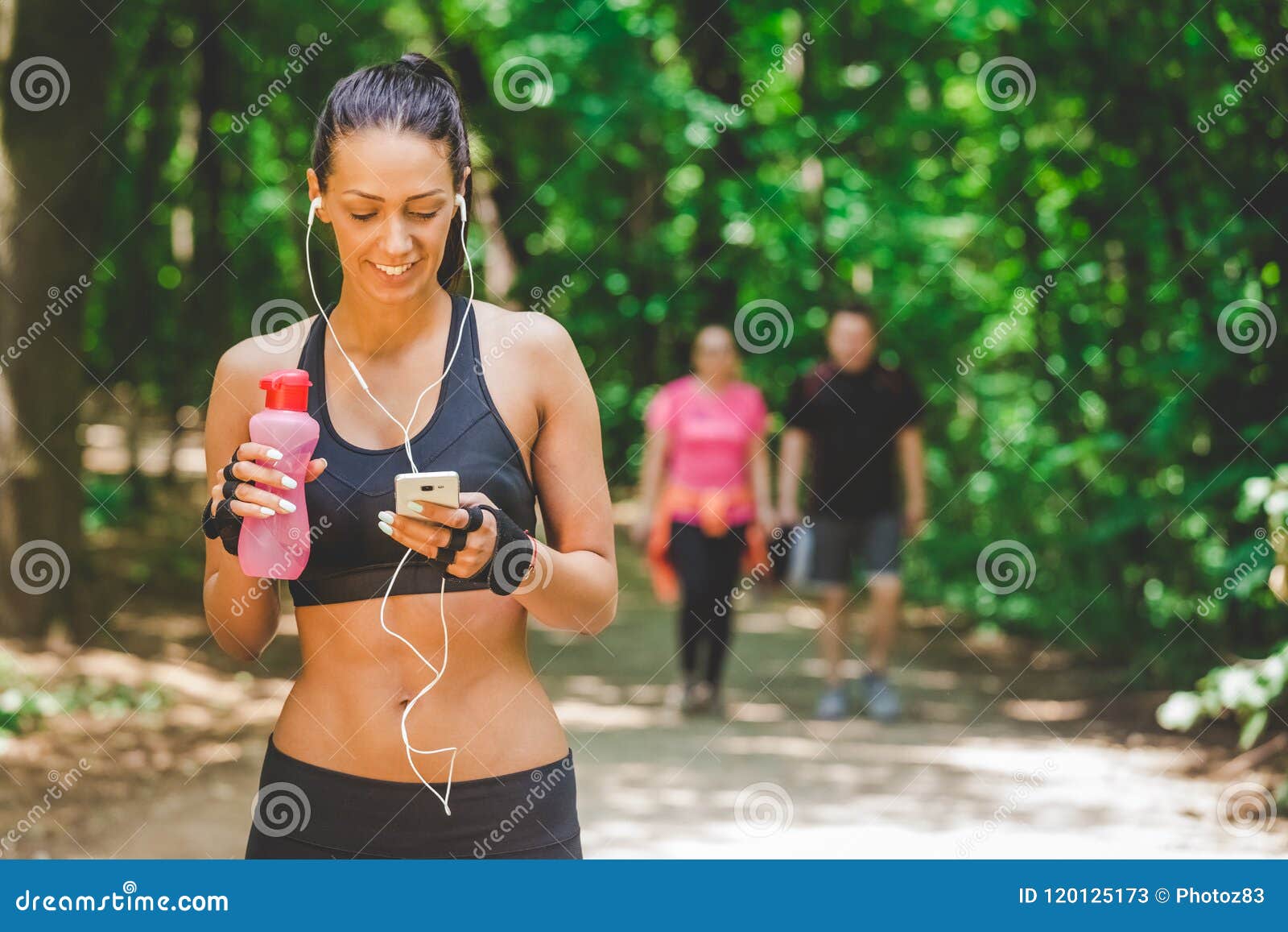 Sportswoman Using Smartphone App and Walking on Running Track in the ...