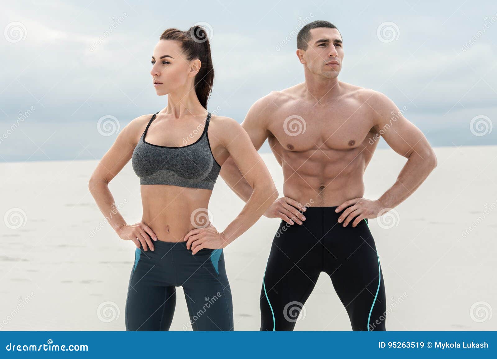 sporty fitness couple showing muscle outdoors. beautiful athletic man and woman, muscular torso abs