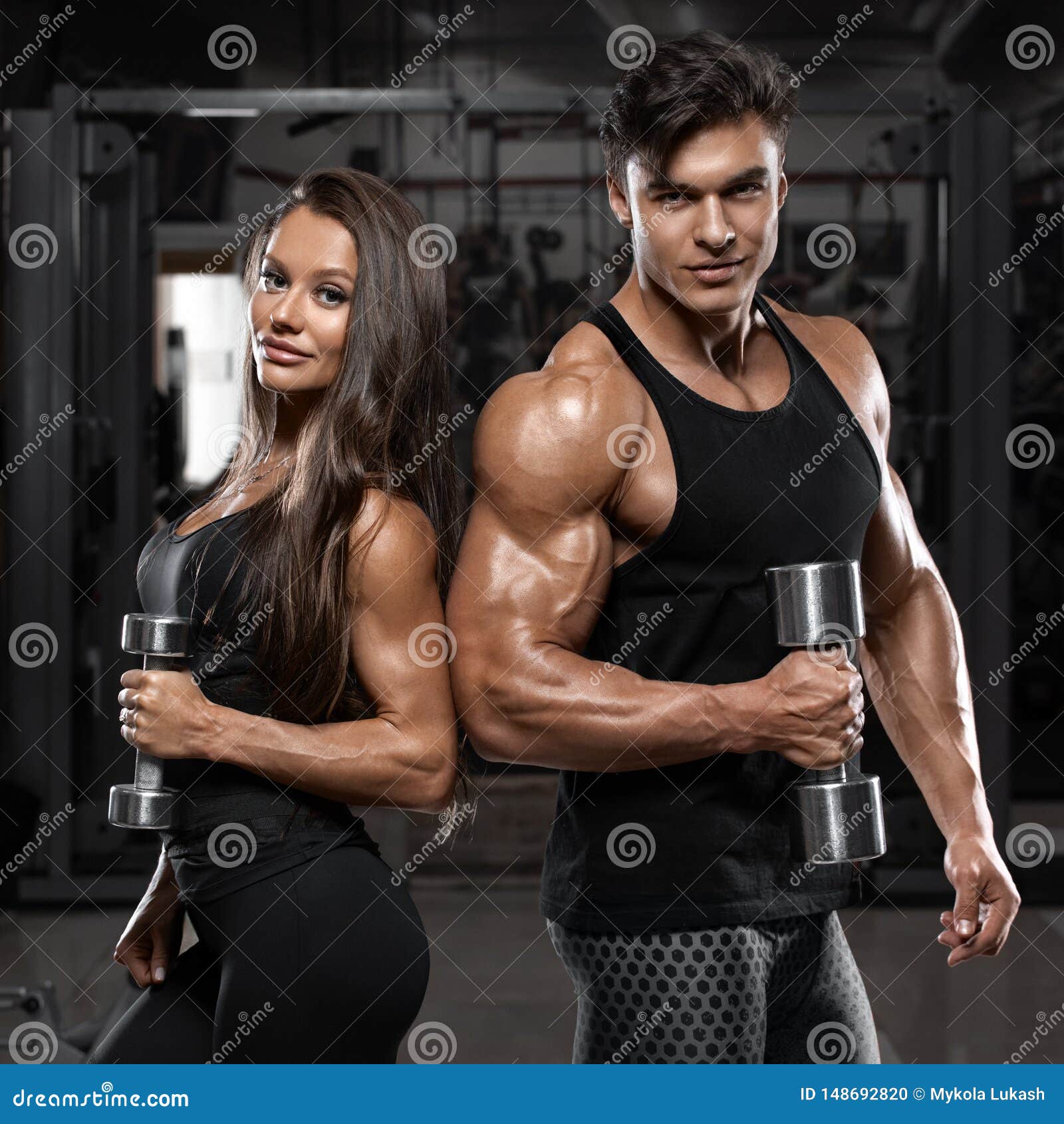 sporty sexy couple showing muscle and workout in gym. muscular man and wowan