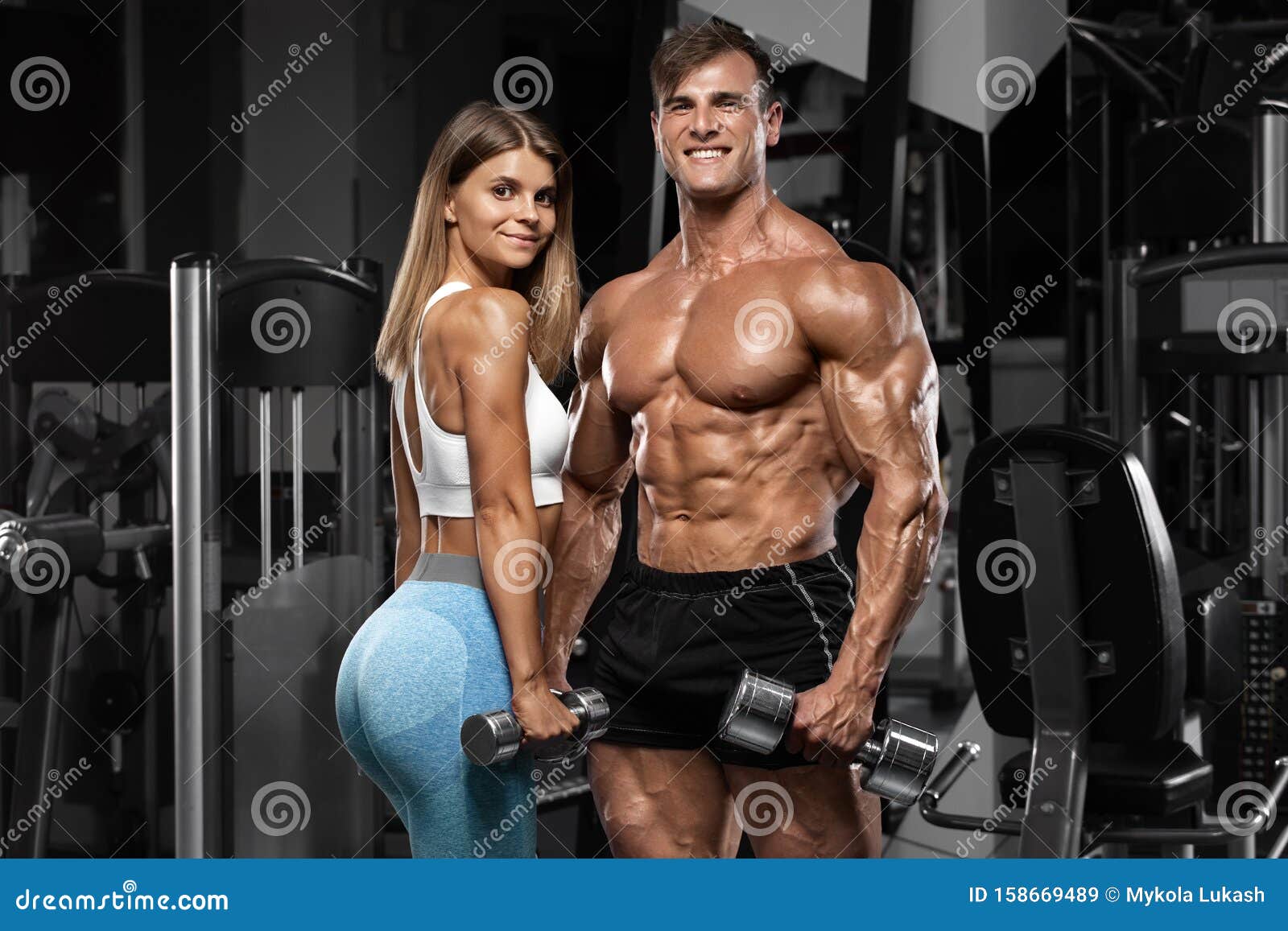 sporty sexy couple showing muscle and workout in gym. muscular man and wowan