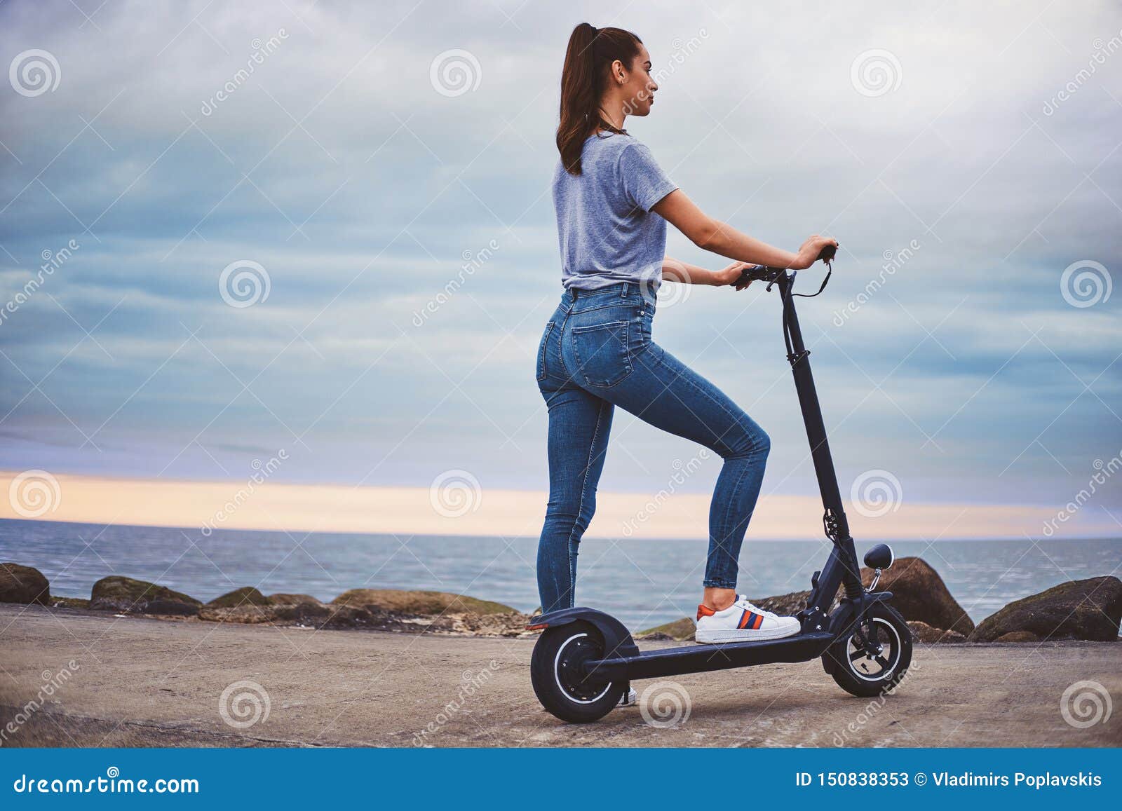Sporty Woman is Riding Electro Scooter by Image - Image adult, person: