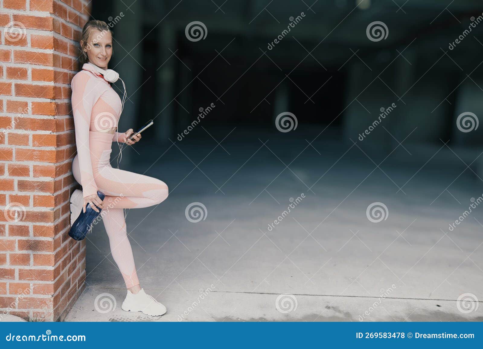 Sporty Young Woman Wearing Pink Sports Clothing is Using Smartphone and  Headphone while Resting after Exercising Stock Photo - Image of music,  icon: 269583478