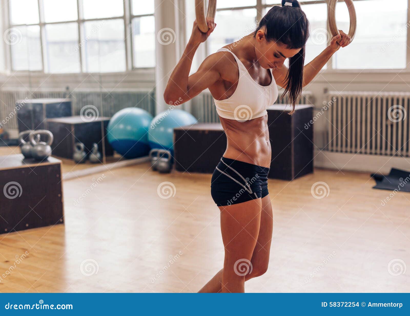 Determined woman exercising with gymnastic rings in gym stock photo  (123608) - YouWorkForThem