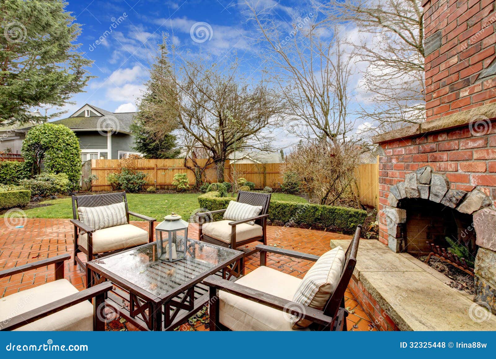 spring backyard with outdoor fireplace and furniture.