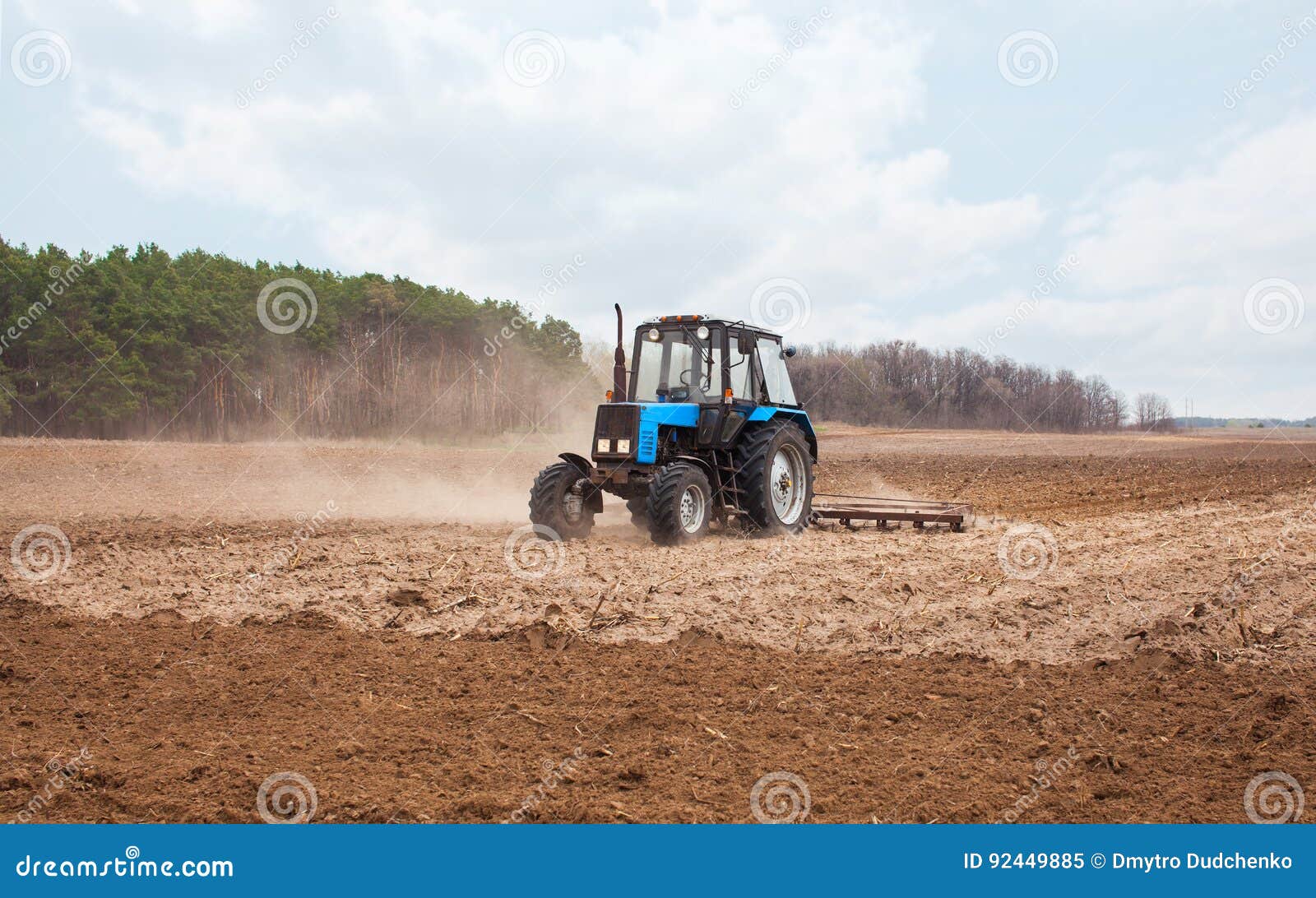 A Spring Day the Tractor Goes and Pulls a Plow Plowing a Field Stock