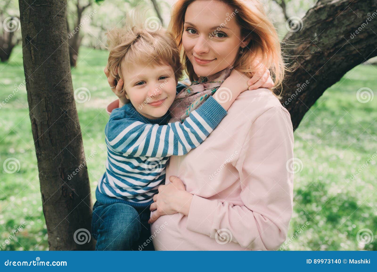 Spring Portrait of Happy Pregnant Mother Enjoying Warm Day with Child