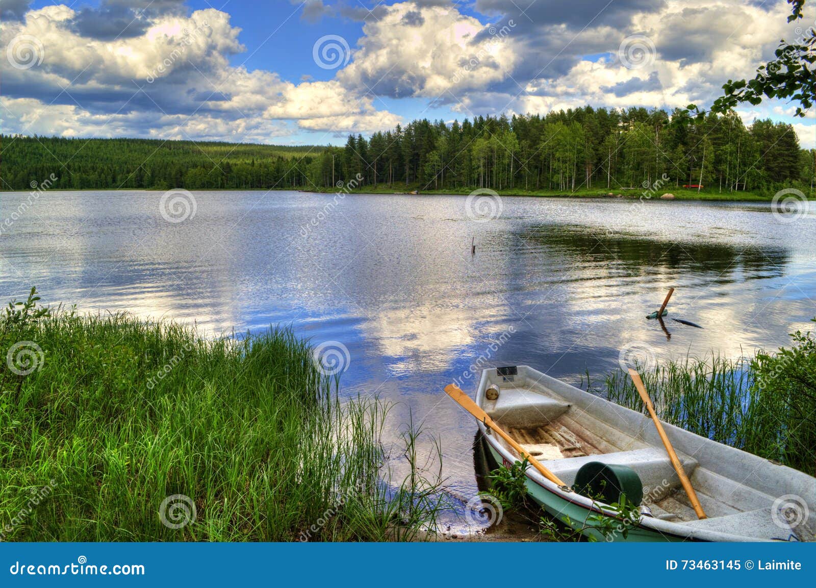 spring summer landscape blue sky clouds river boat green trees in sweden