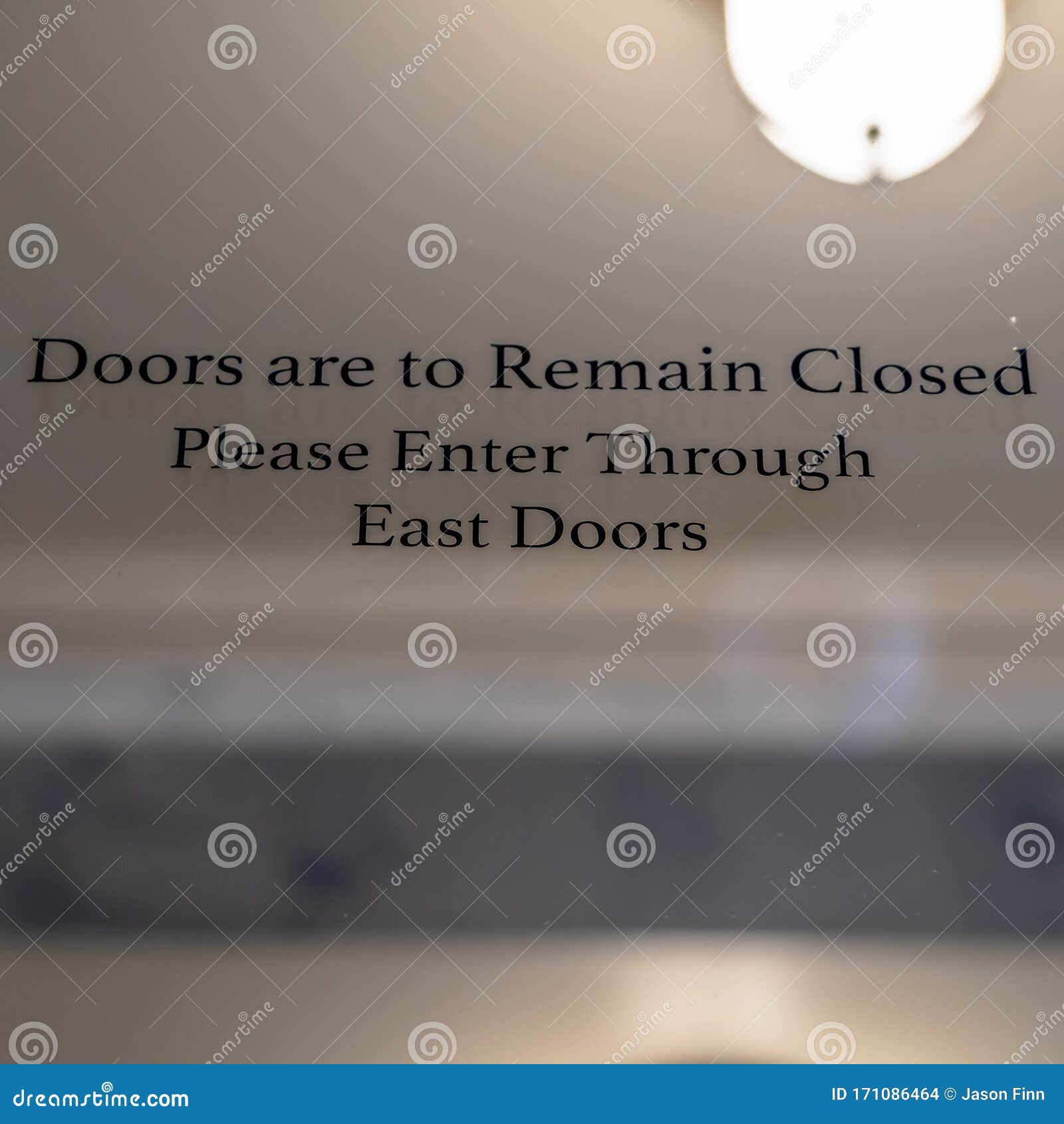 square doors are to remain closed sign on the glass door of a building exterior