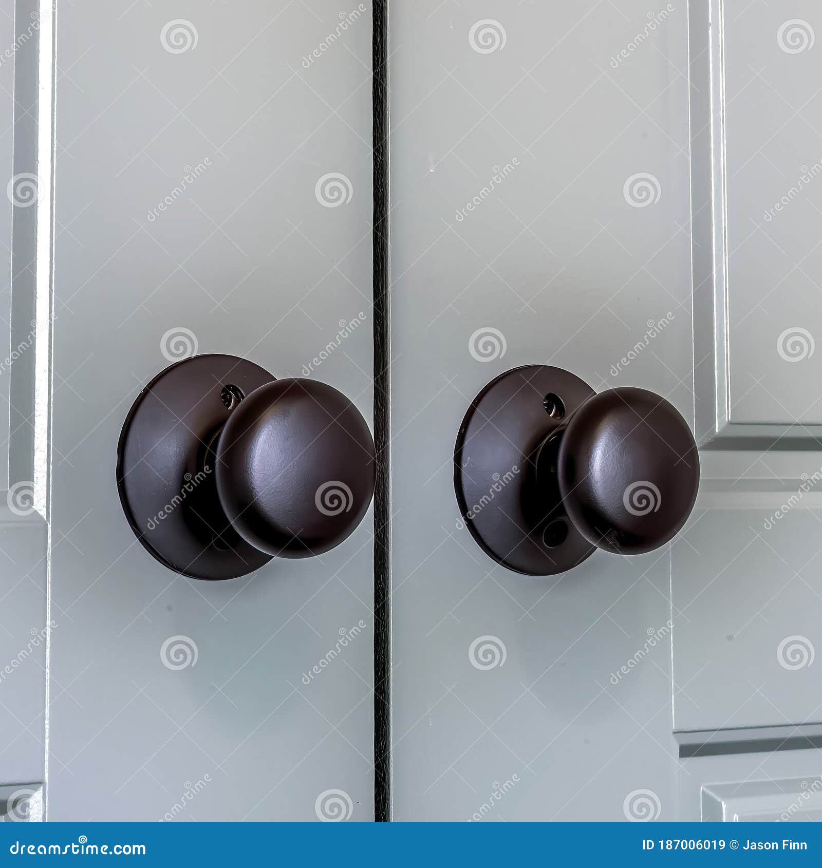 Square Matte Black Round Door Knobs of a Double Door with Paneling