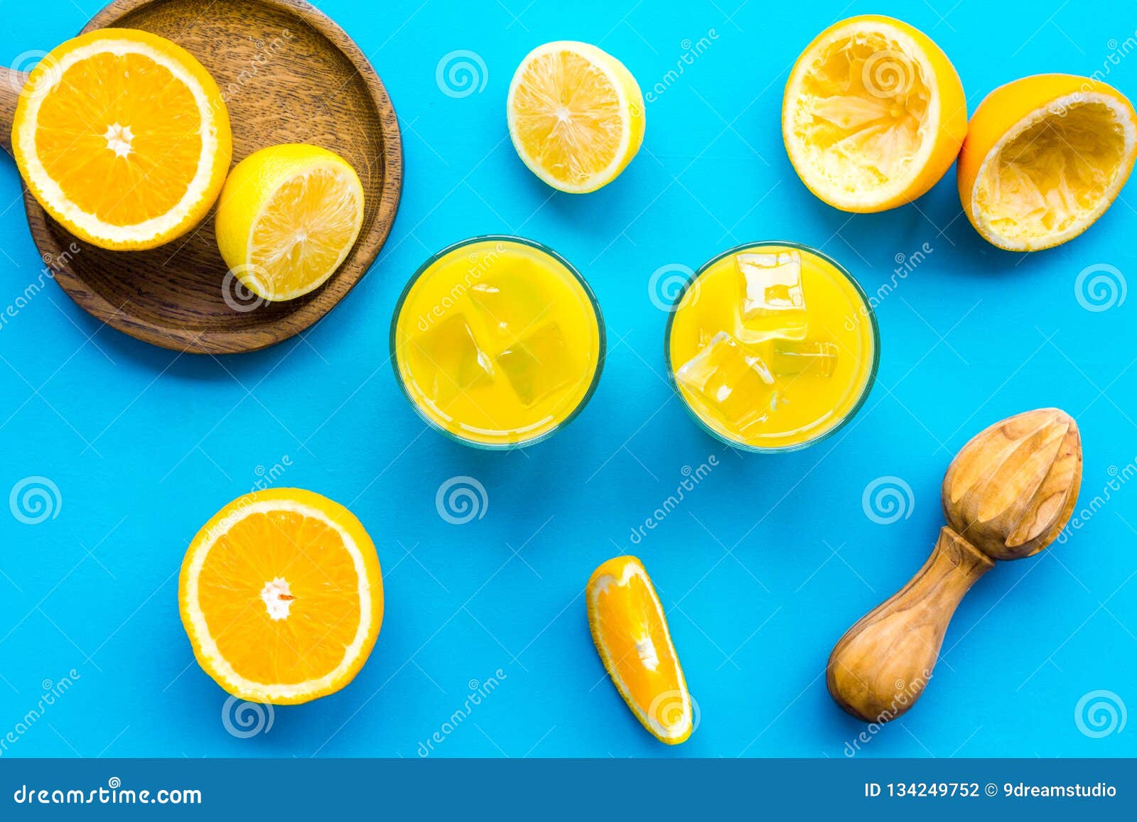 Squeeze Fresh Oranges With Juicer. Orange Juice In Glass Near Half Cut Oranges On Blue ...