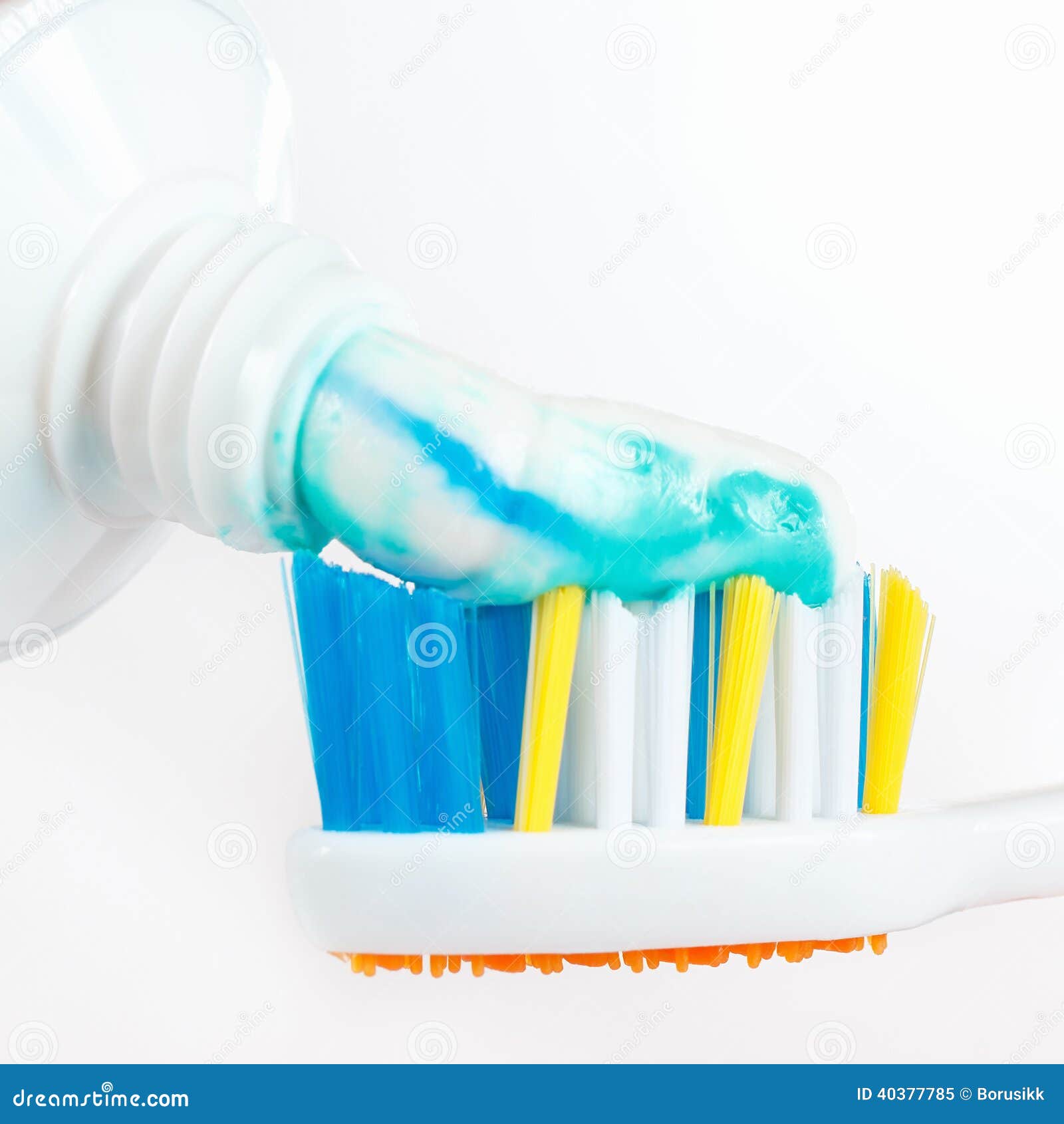 Squeezing Toothpaste from a Tube on the Toothbrush Closeup Stock Image
