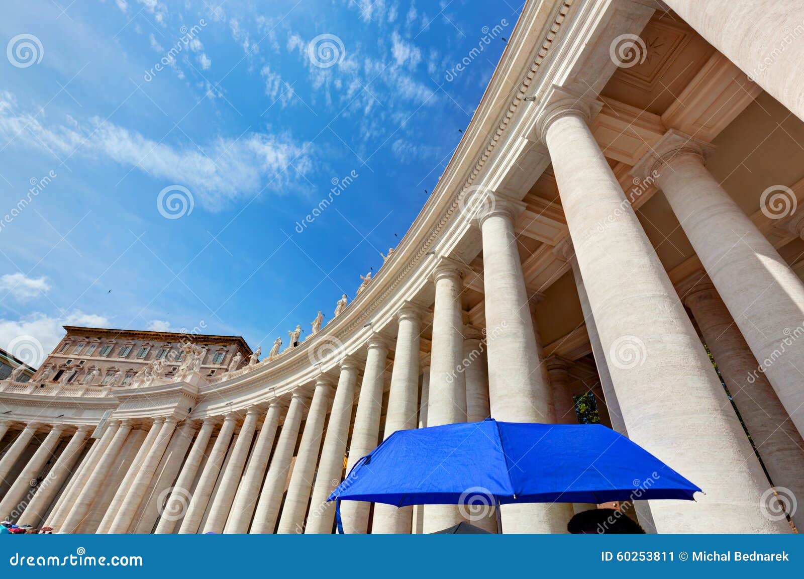 st. peter's basilica colonnades in vatican city. blue umbrella harmonizes with sky
