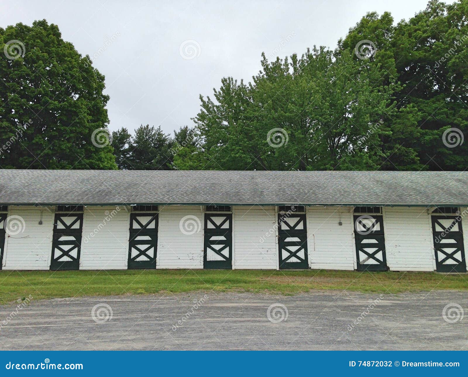 Stables at a Horse Track with Trees and Dirt Road Stock Photo Image