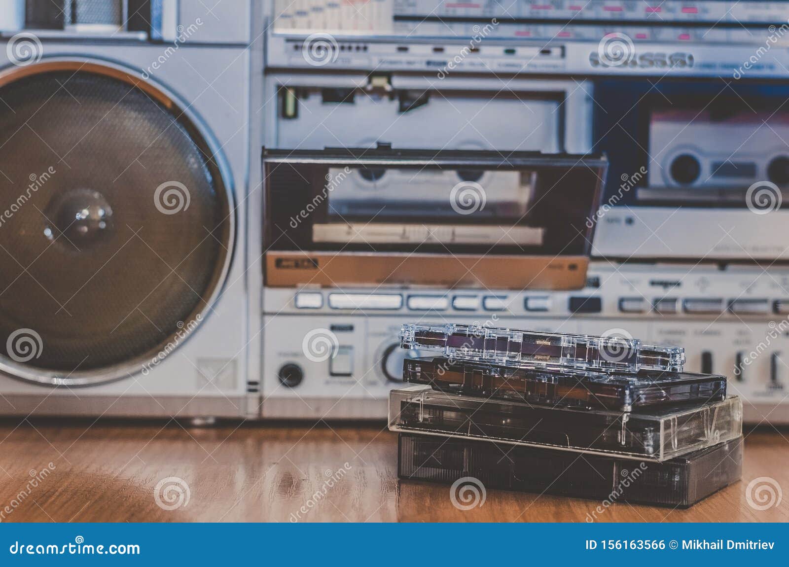 Retro outdated portable stereo boombox radio cassette recorder from circa  late 70s with aged headphones front gradient black wall background.  Listening music concept. Vintage old style filtered photo Stock Photo