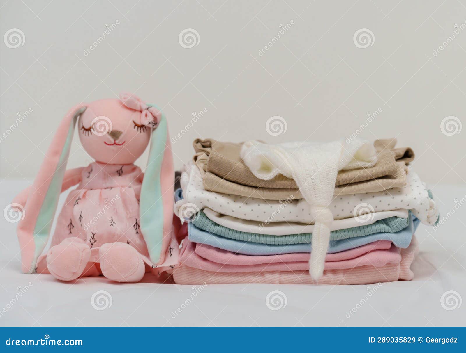 Stack of Baby Clothes and Toy on Bed Stock Image Image of background