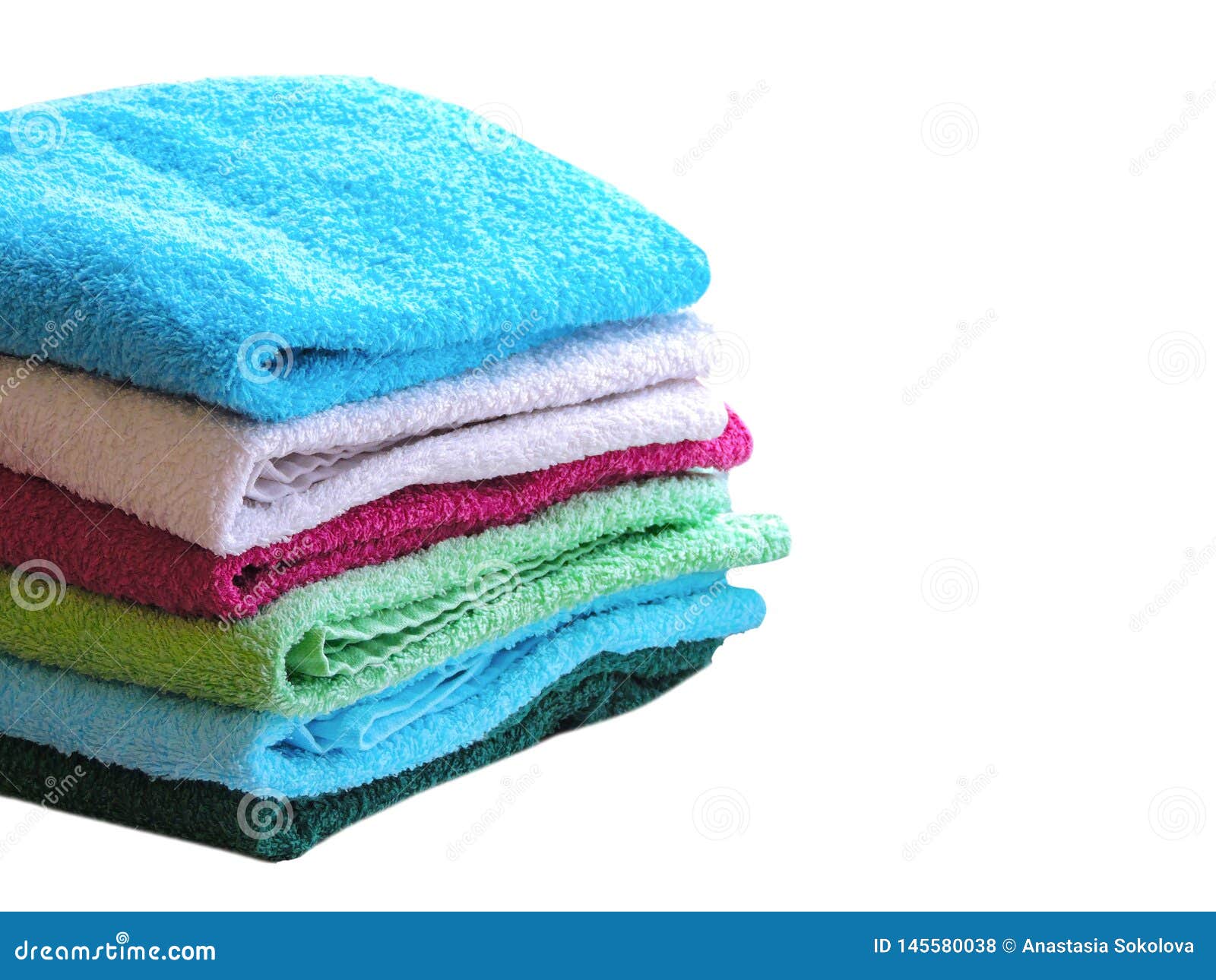 stack of bath towels on light wooden background closeup.pile of rainbow colored towels.top view.
