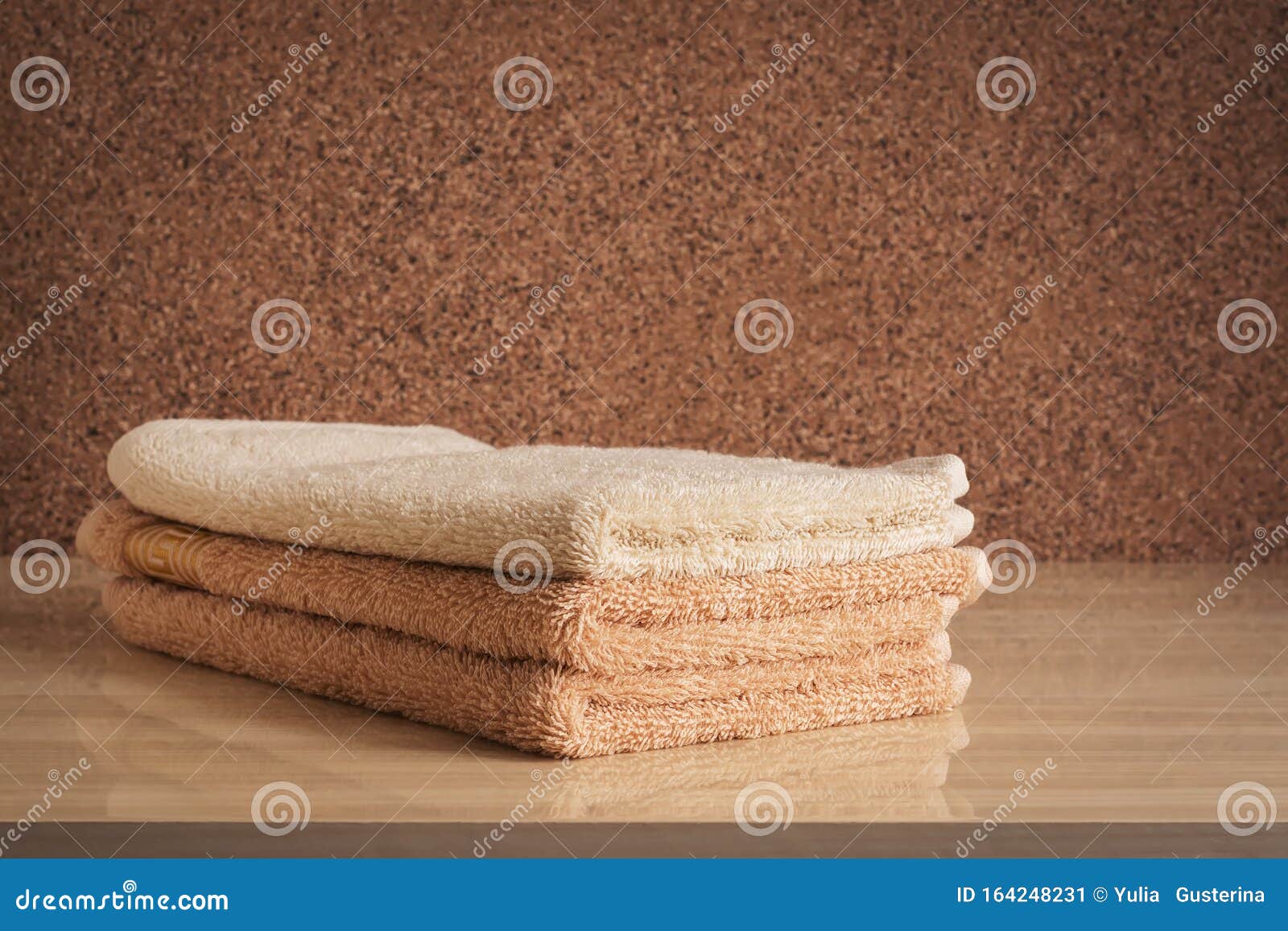 A Stack Of Beige Terry Towels On A Chest Of Drawers Selective