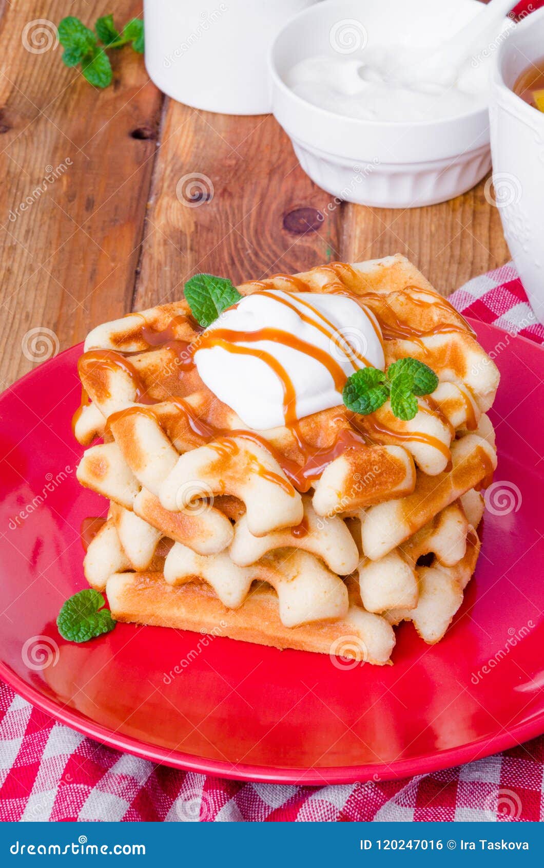 Stack Belgian Waffles with Caramel Sauce and Whipped Cream on a Plate