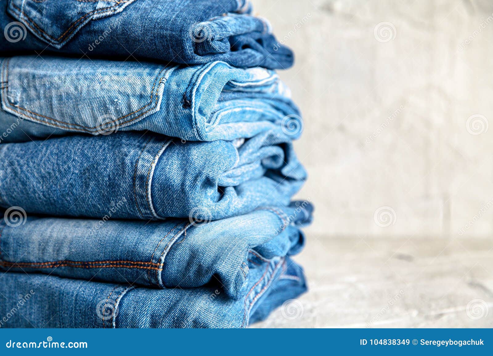 Stack of Blue Jeans on a Gray Background Stock Image - Image of blue