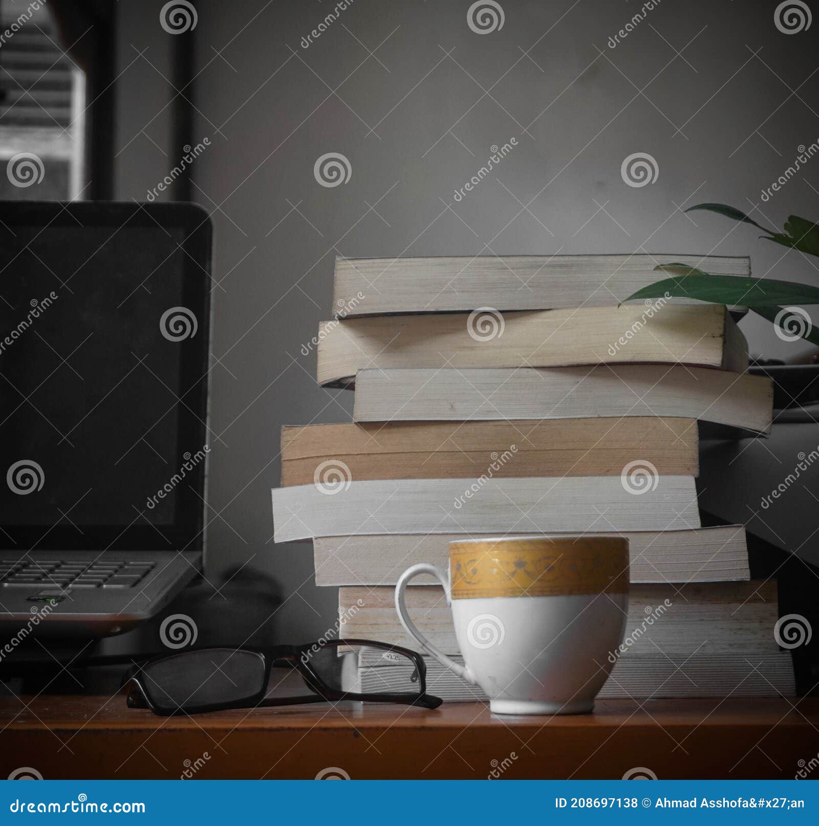 stack of books and coffee, glass, and laptopp