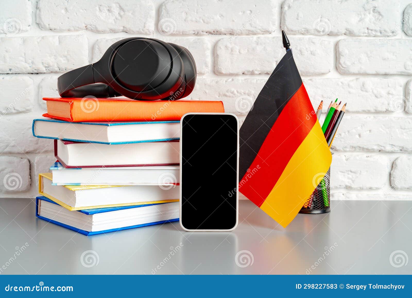 Stack of Books and Flag of Germany on Desk. German Language Learning