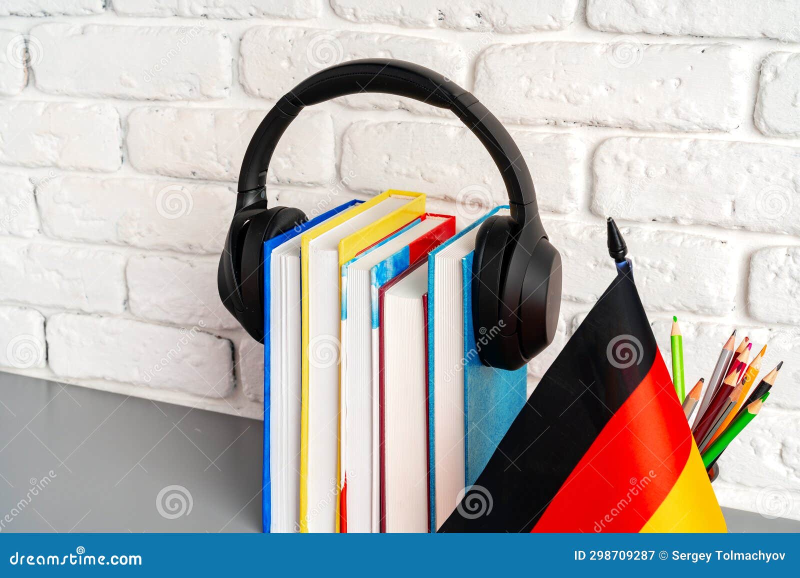 Stack of Books and Flag of Germany on Desk. German Language Learning