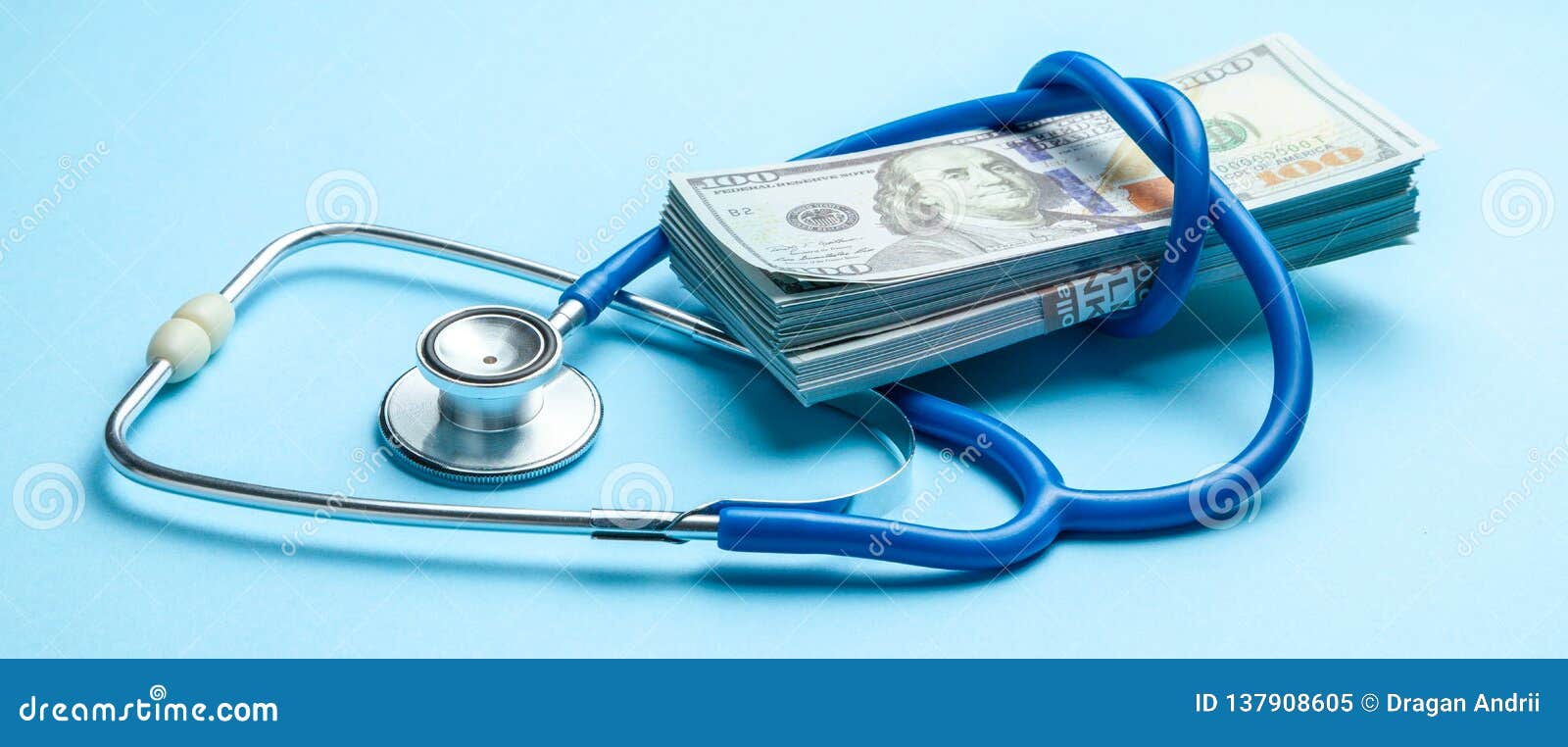 stack of cash dollars and stethoscope on blue background. the concept of medical strechevka or expensive medicine, doctors salary