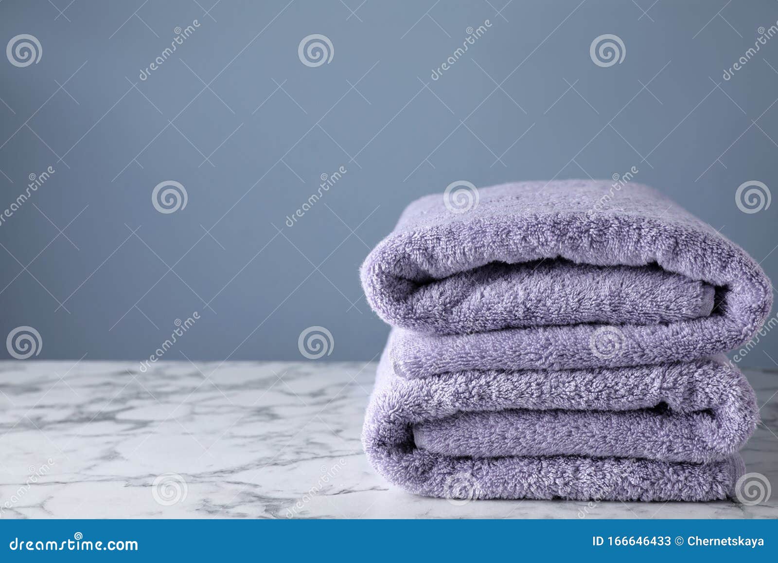 Stack of Clean Bath Towels on Marble Table. Space for Text Stock Image