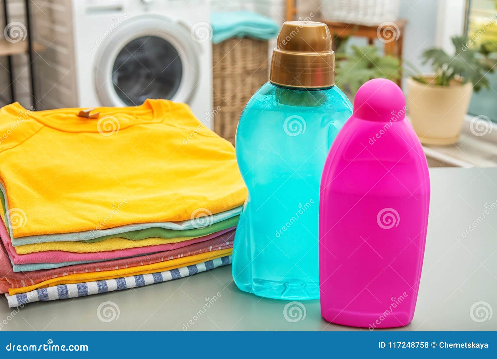 Stack of Clean Clothes and Bottles with Detergents Stock Photo - Image