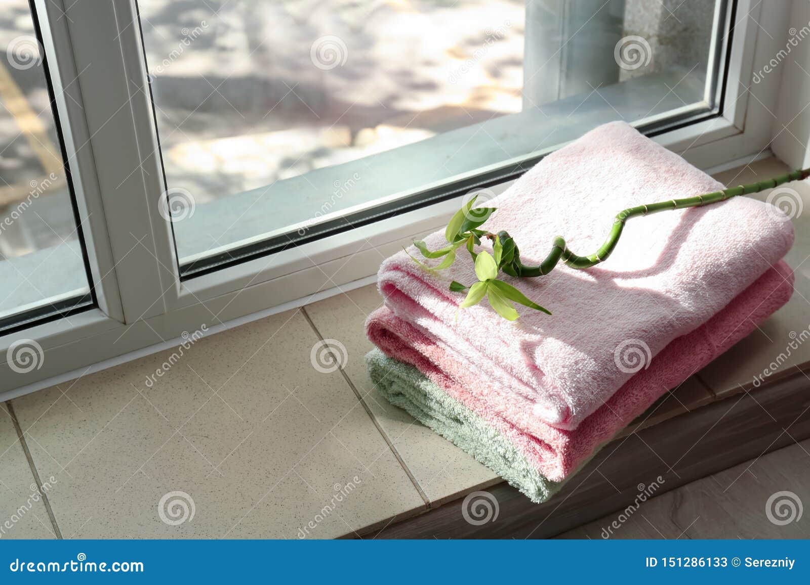Stack of Clean Soft Towels with Tropical Plant on Windowsill Stock