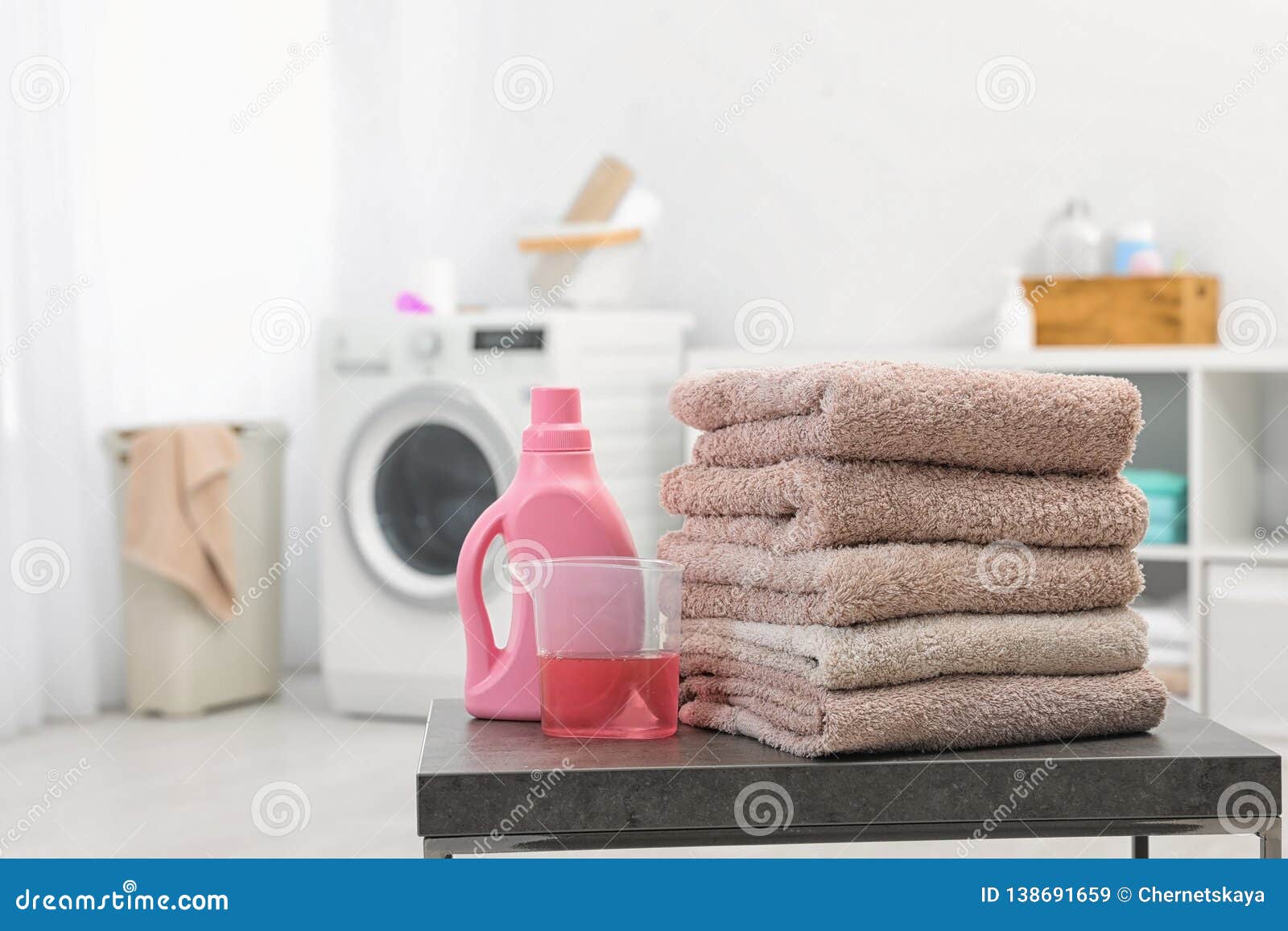Stack of Clean Towels and Liquid Detergent on Table in Bathroom Stock