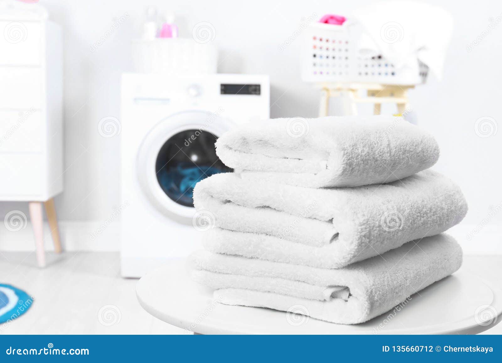 Stack of Clean Towels on Table in Laundry Room. Stock Photo Image of