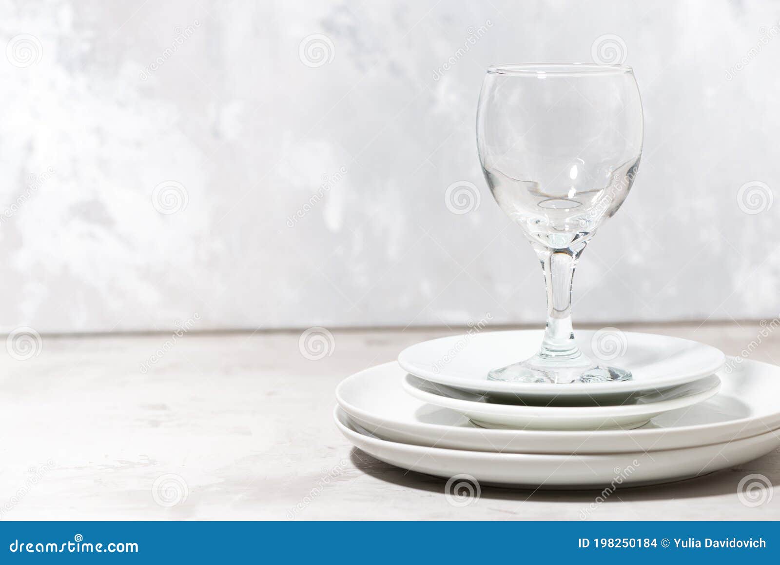 Stack of Clean White Plates and a Wine Glass. Serving Element Stock