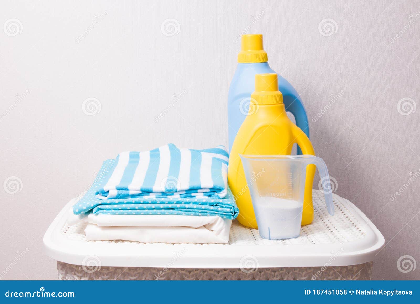 A Stack of Colored Laundry, Detergent in a Measuring Cup and Washing