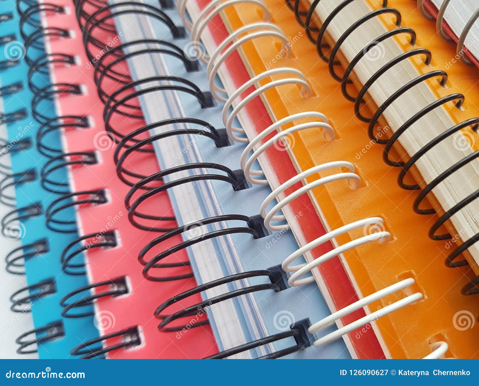 notebook spiral. stack of colorful copybooks.  on a white background. notebook color - pink, orange, blue.