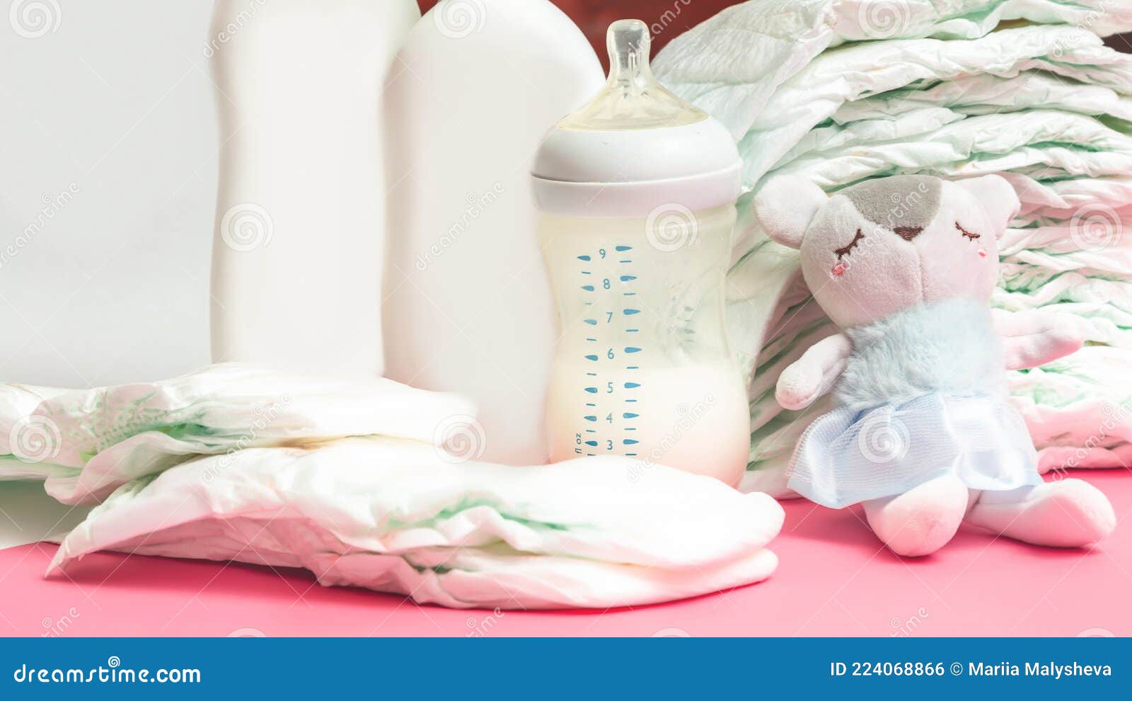 Stack of Diapers with Teddy Bear Toy Lying on White Table, Bottle for ...