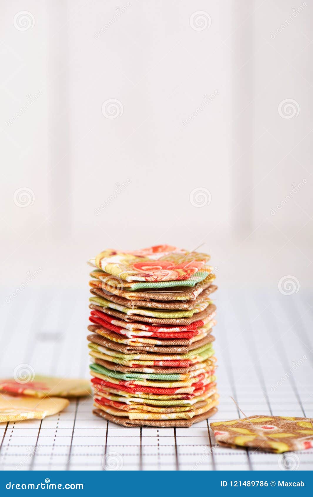 Stack English Paper Pieced Hexagons on White Craft Mat Stock Photo