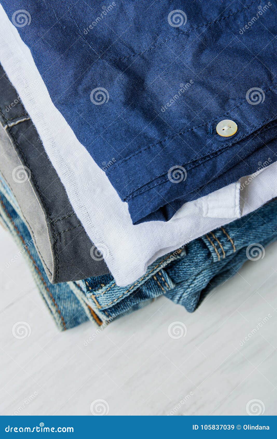 Stack of Folded Cotton Pants Shirts Jeans on White Wood Background ...