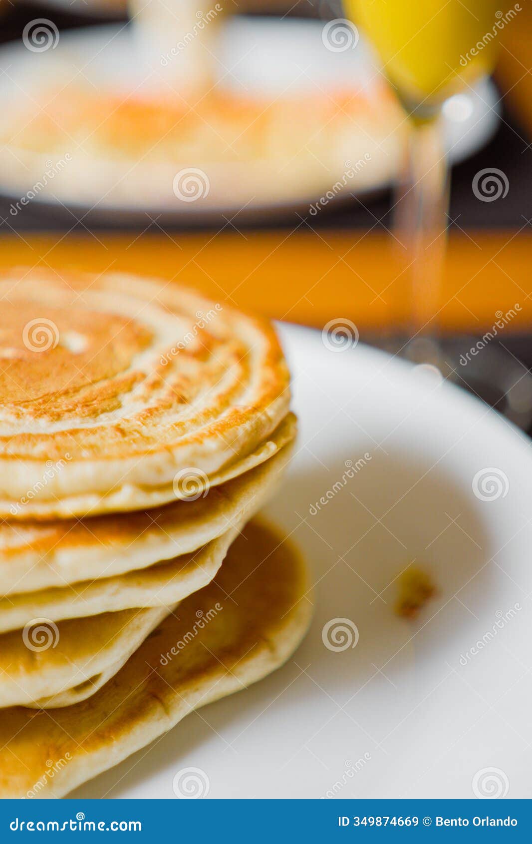a stack of fresh pancakes served on a white plate in a cozy breakfast setting