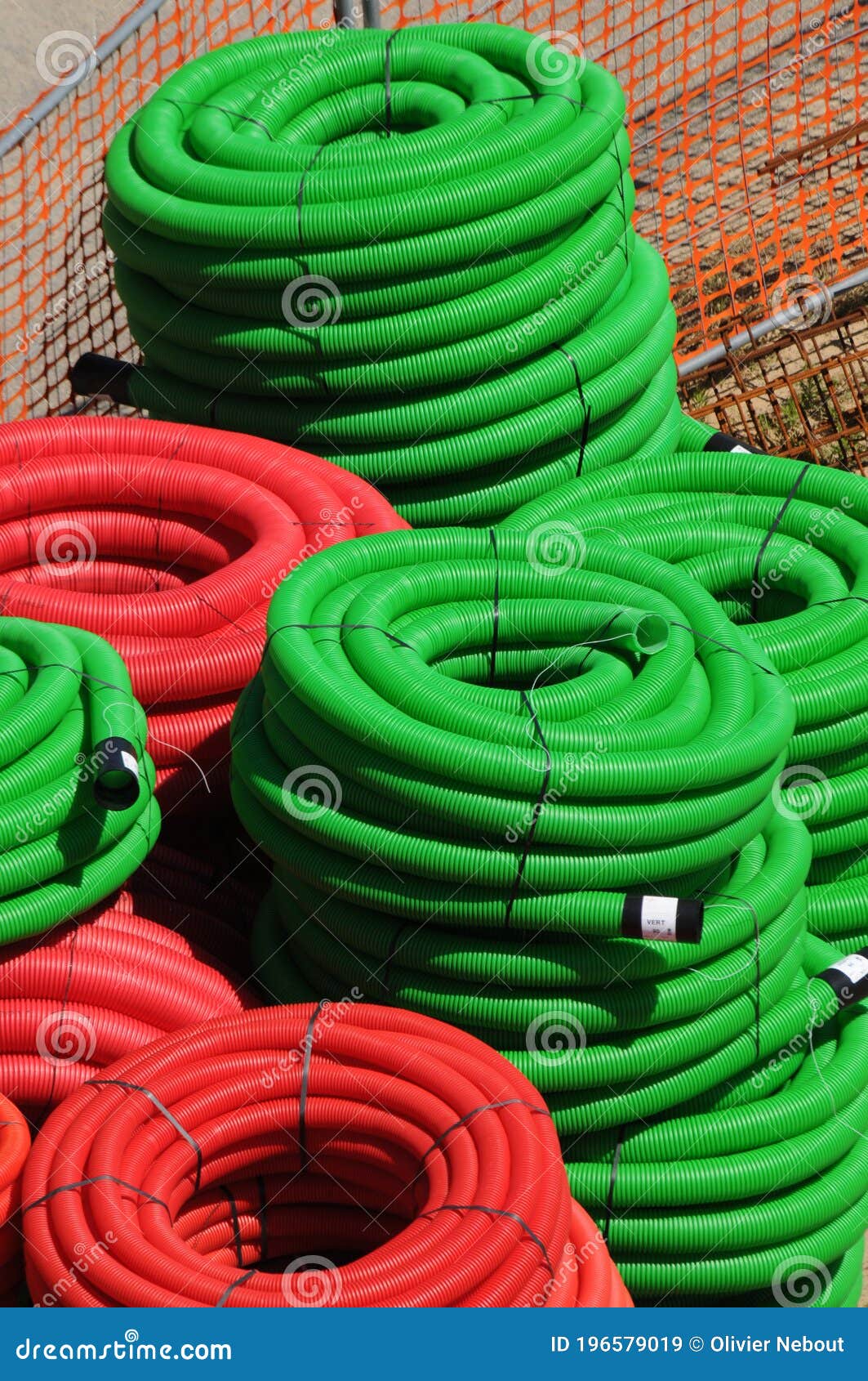 A Stack of Green and Red Underground Cable Protective Sleeves Pipes for Electrical Cable or Wire