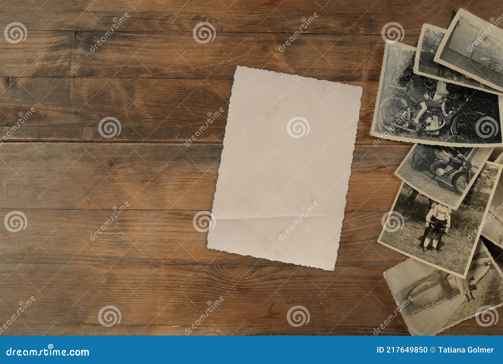 stack of old vintage monochrome photographs on photographic paper on natural wood background, concept of genealogy, memory of